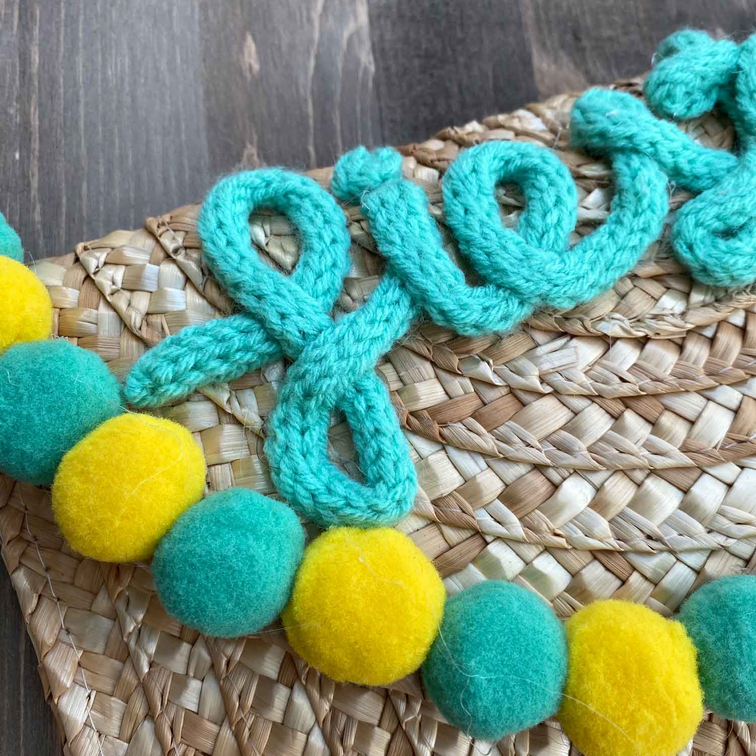 Pochette in paglia Ibiza con scritta personalizzata e pon pom gialli/azzurri