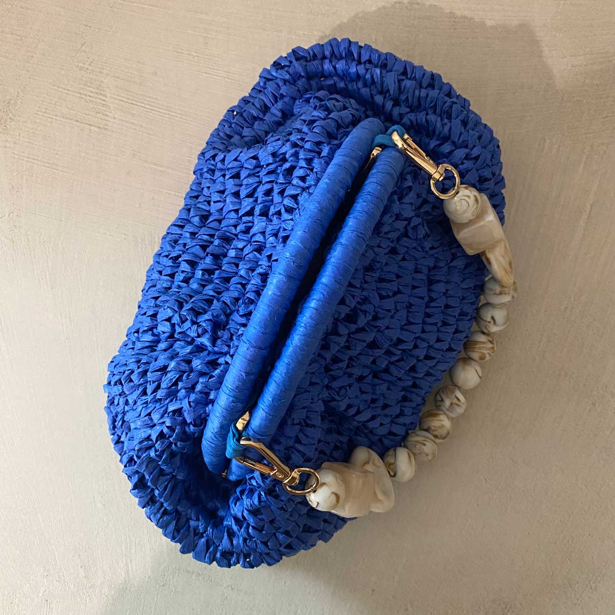 Clutch in rafia all’uncinetto blu con manico in pietra naturale