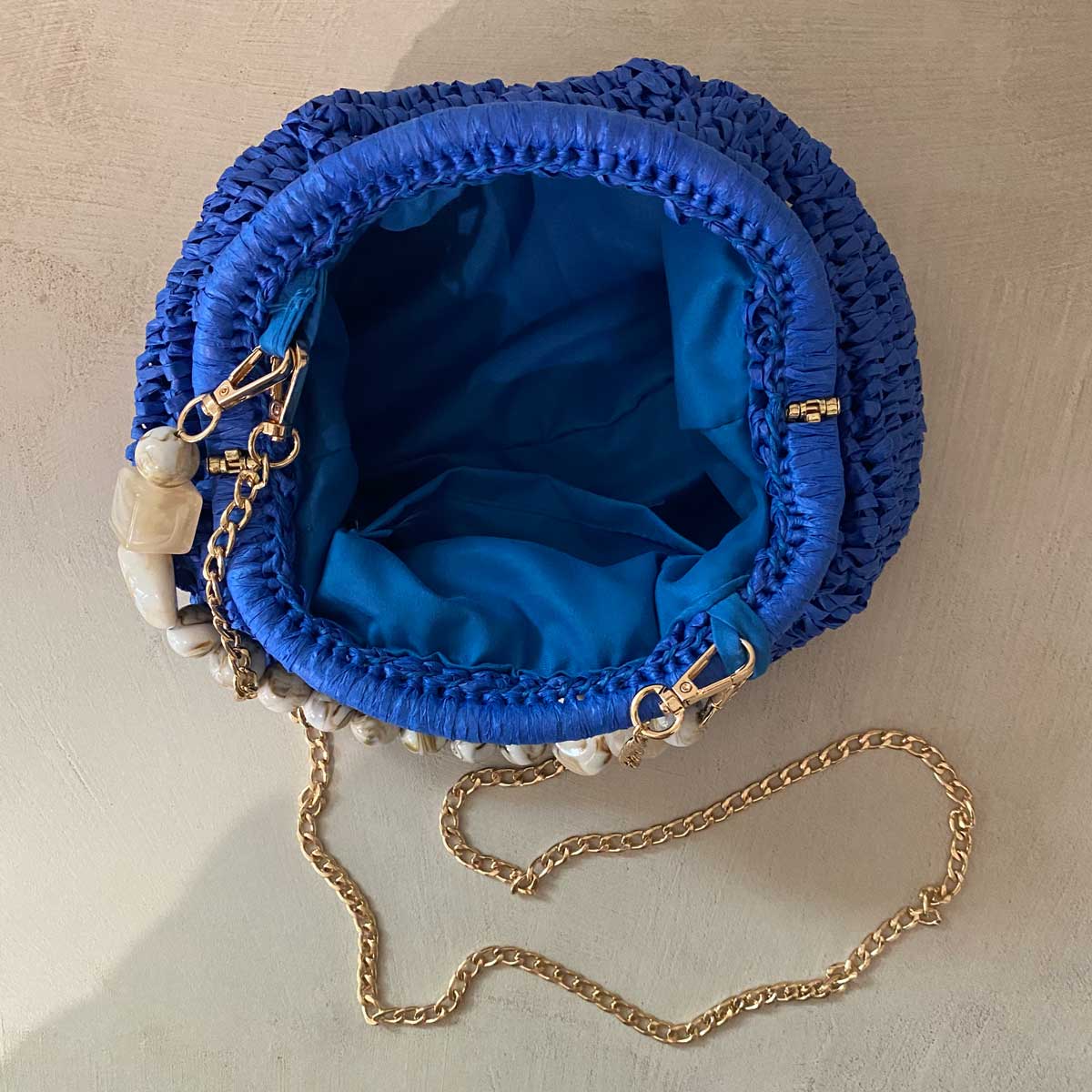 Clutch in rafia all’uncinetto blu con manico in pietra naturale