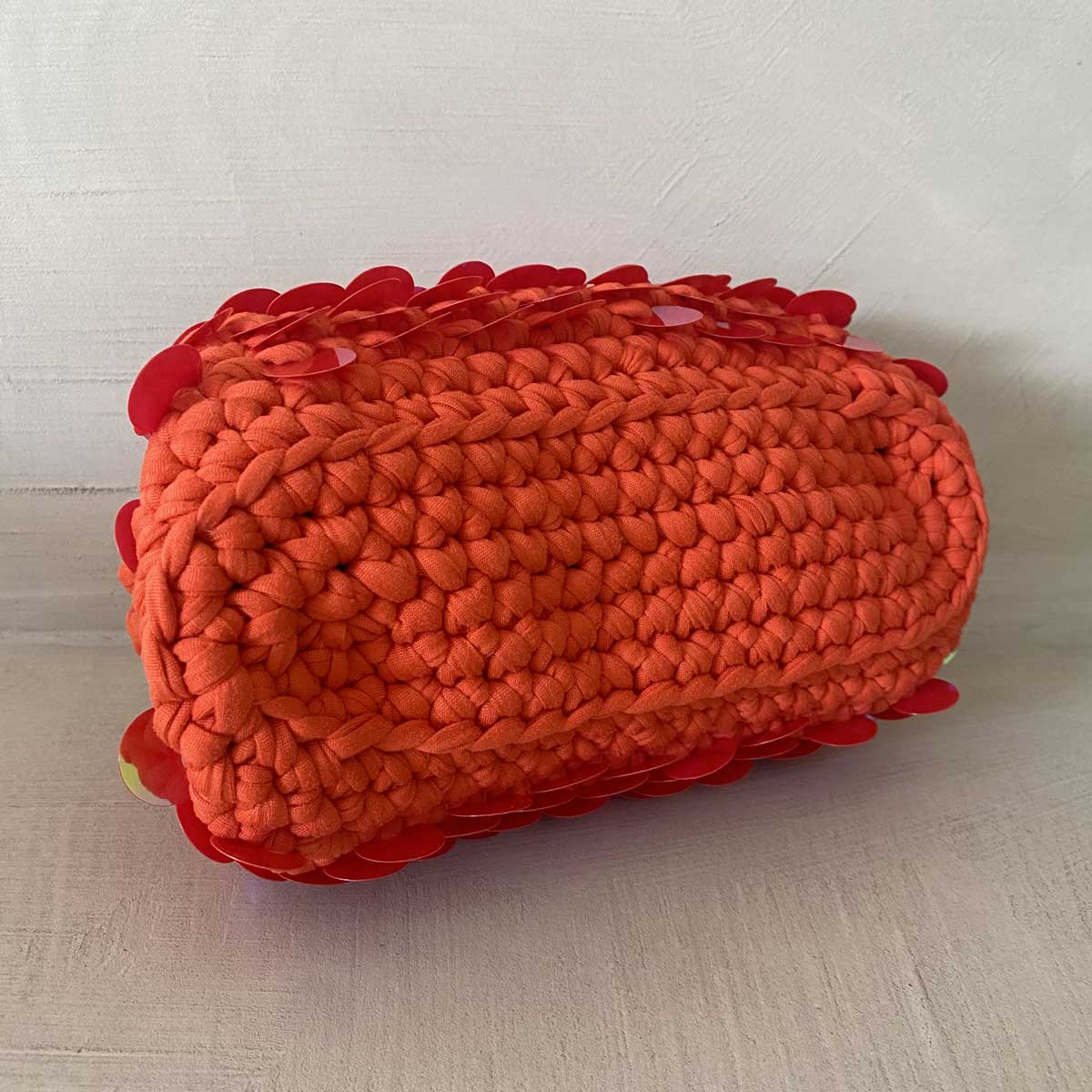 Clutch bag all'uncinetto arancione con paillettes olografiche