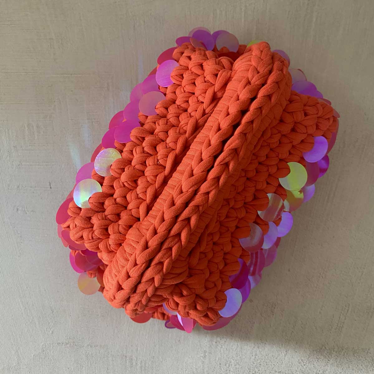 Clutch bag all'uncinetto arancione con paillettes olografiche